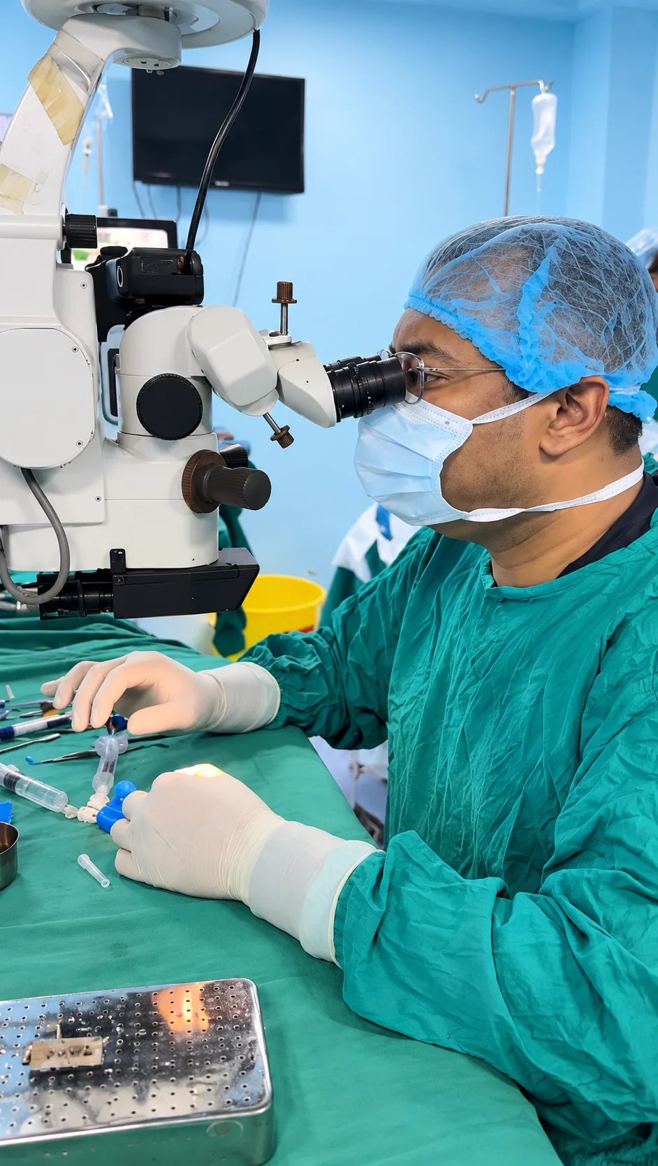 A surgeon at an ophthalmic microscope.